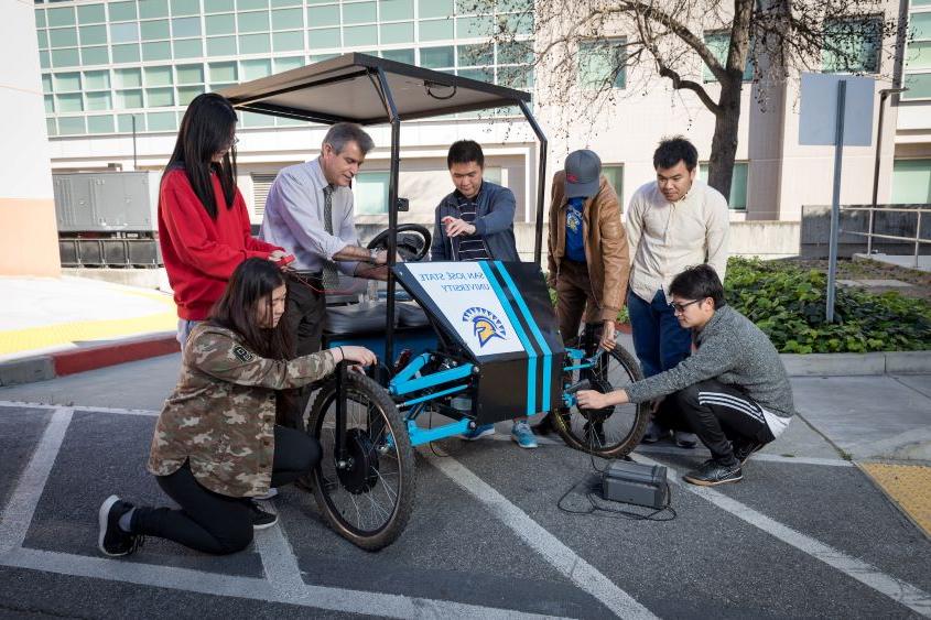 教师导师和学生正在研究太阳能自行车.